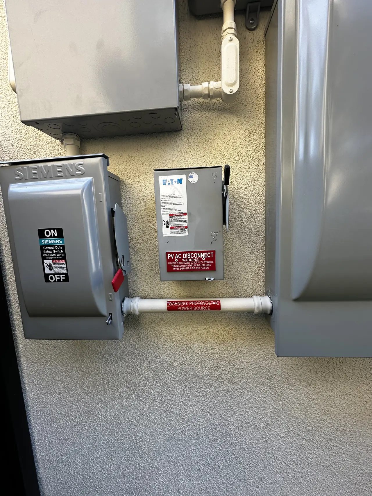 Two closed safety switches side by side on a stucco wall, Porter Ranch
