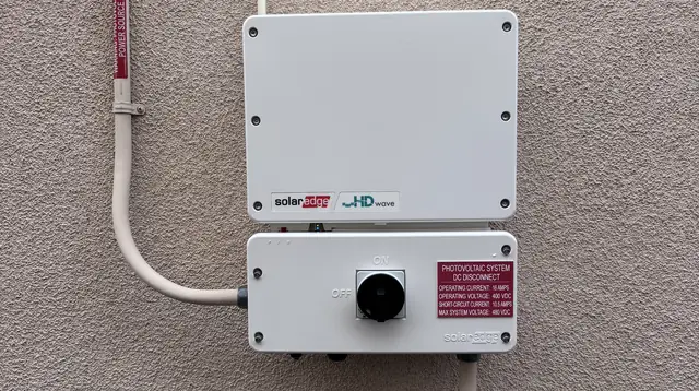 A closed SolarEdge inverter and disconnect on a stucco wall, Porter Ranch