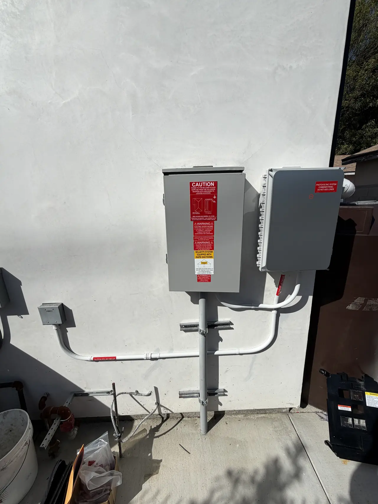 The accessory dwelling unit's own service equipment mounted on the exterior wall, closed and labeled, Reseda