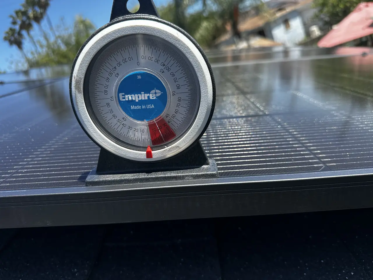 An inclinometer standing on a solar module to measure the tilt of the array, San Fernando