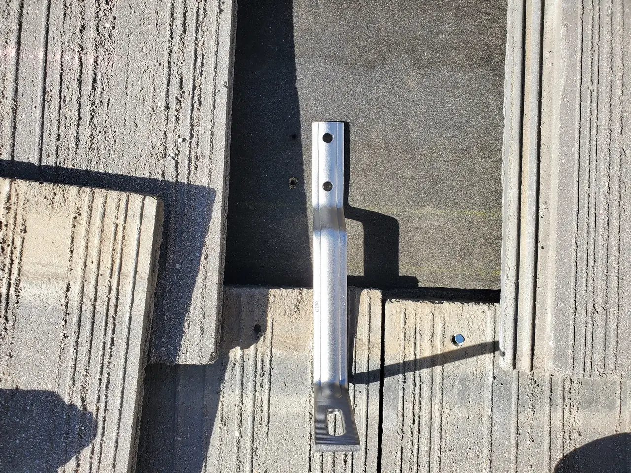 An aluminum L-foot seated between concrete roof tiles, Santa Clarita