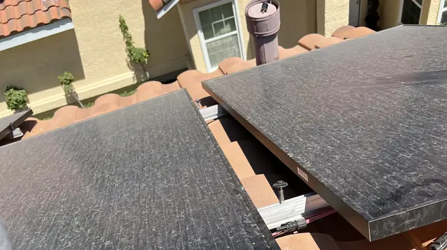 Two solar modules set on a clay tile roof above the neighboring houses, Santa Clarita