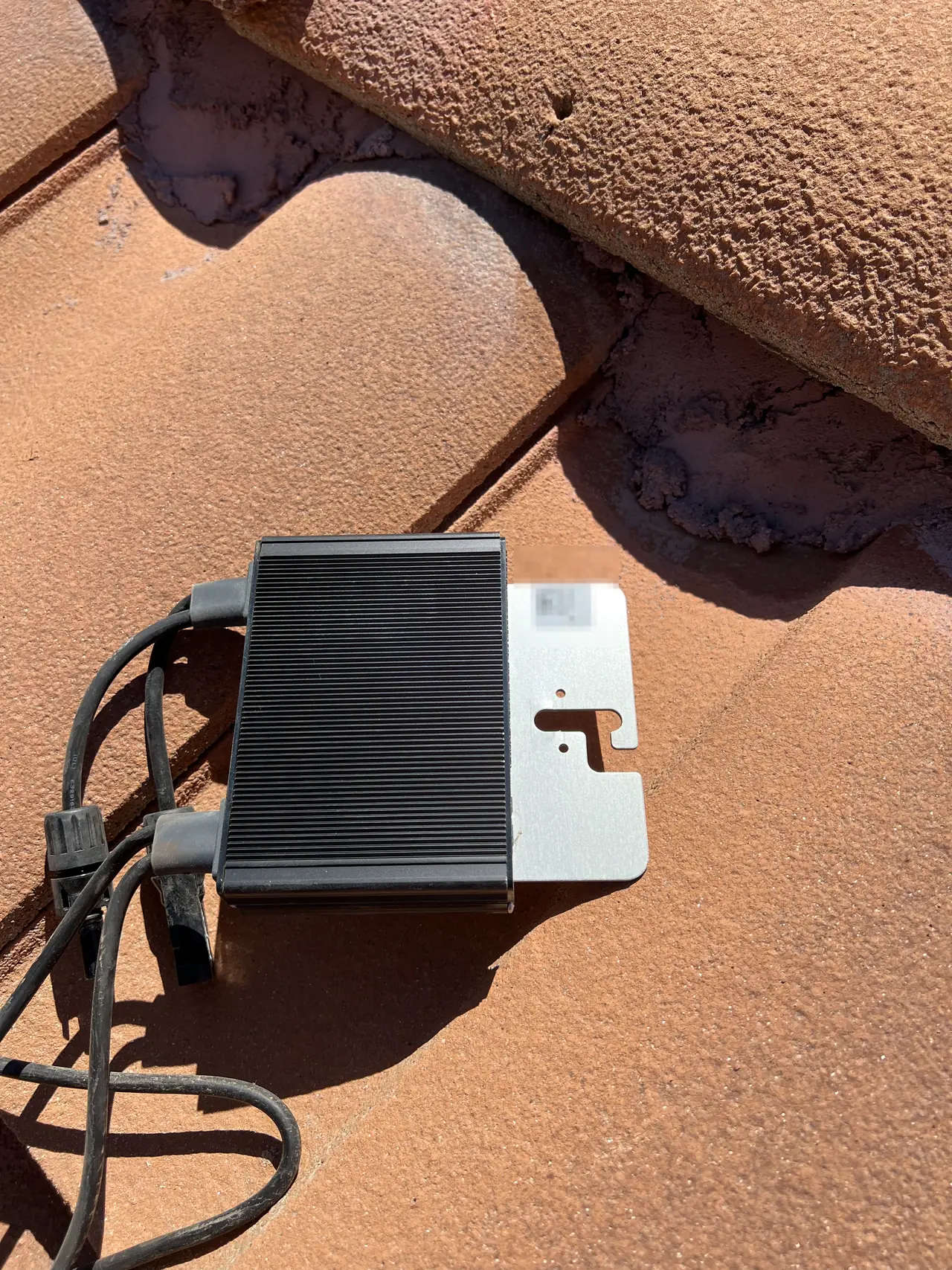 A module-level optimizer mounted on the tile roof beneath the array, Santa Clarita