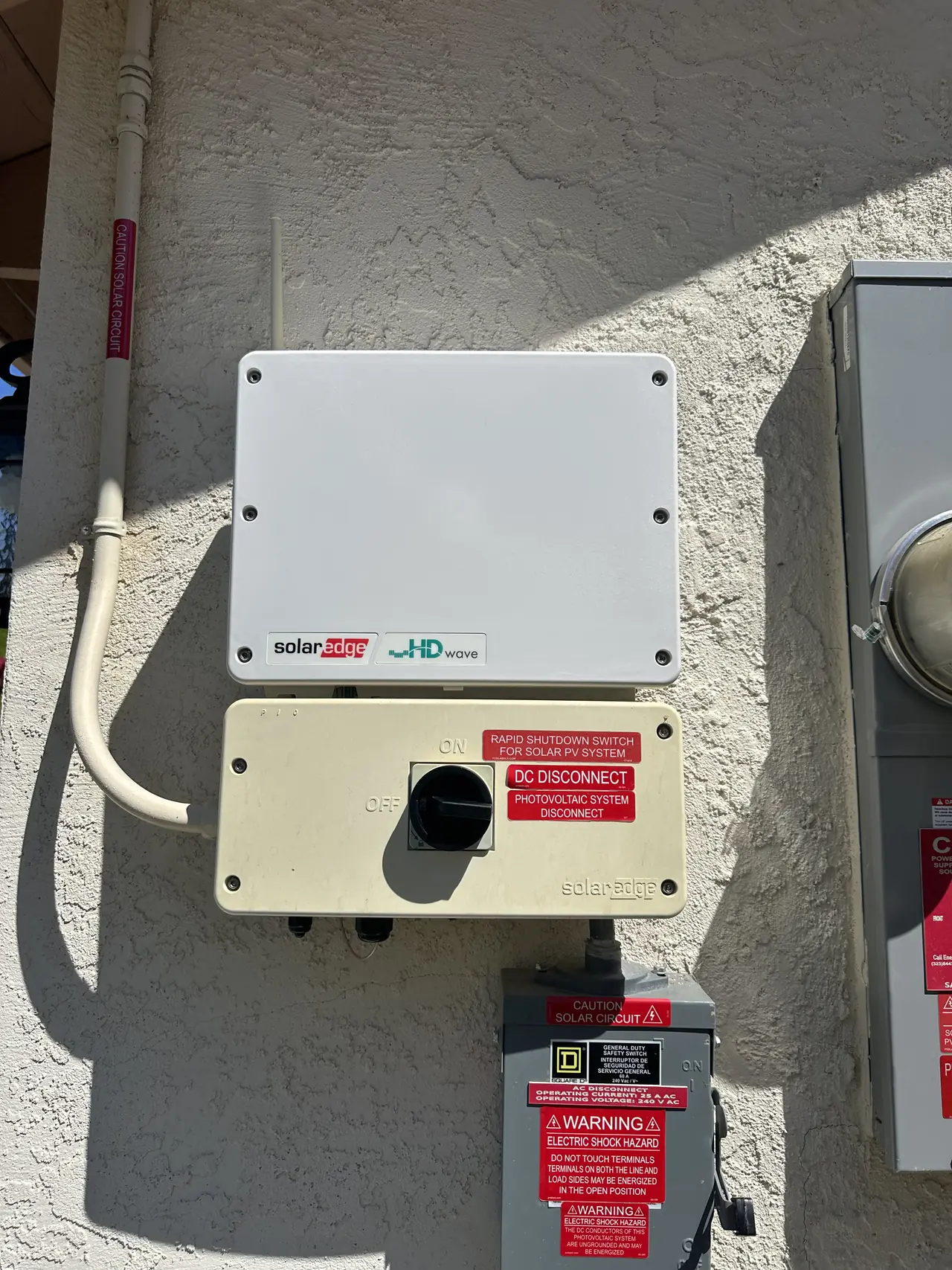 A closed SolarEdge inverter and safety switch on an exterior wall, Santa Clarita