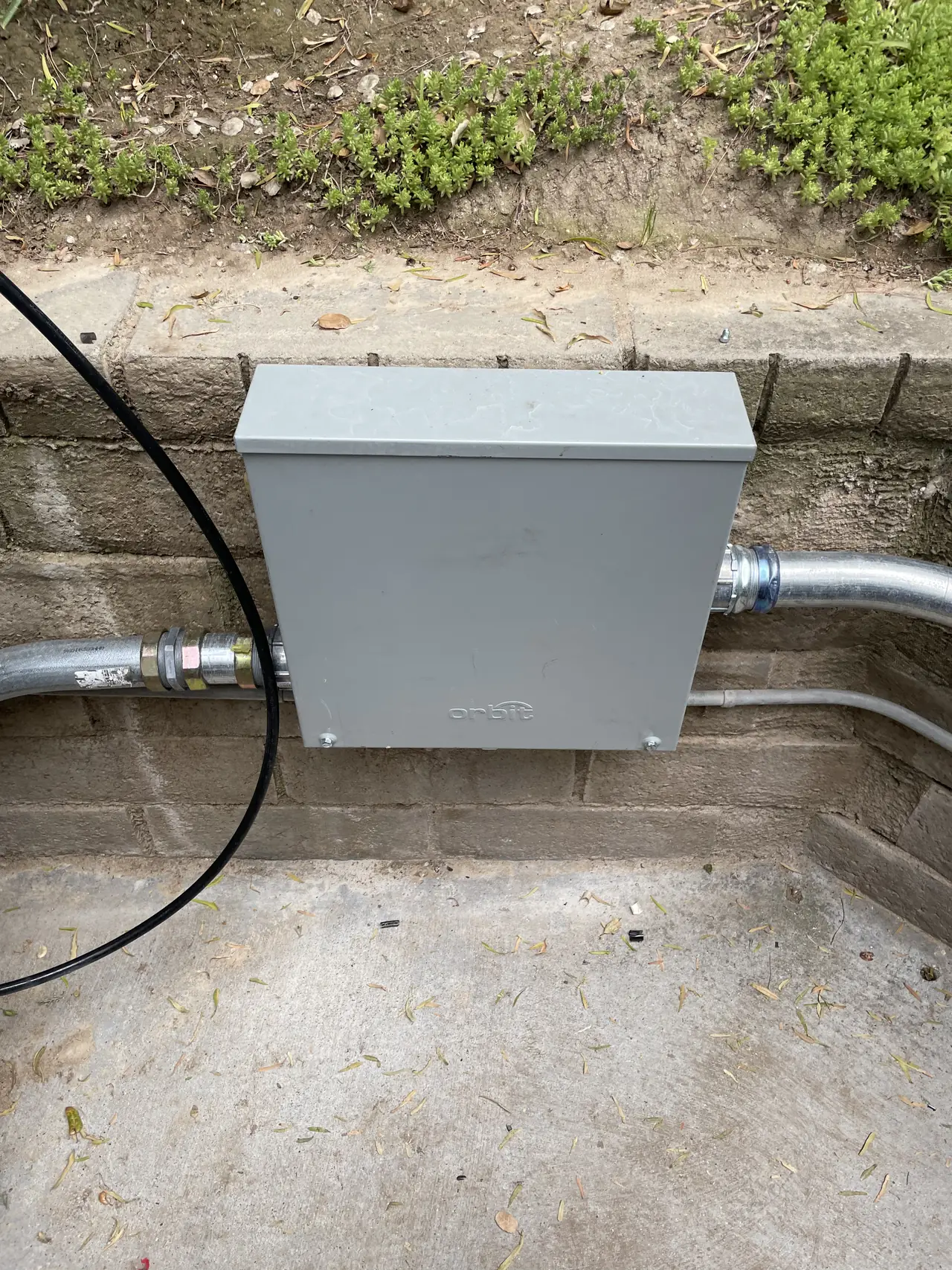 A closed enclosure on the retaining wall with conduit entering from both sides, Santa Clarita