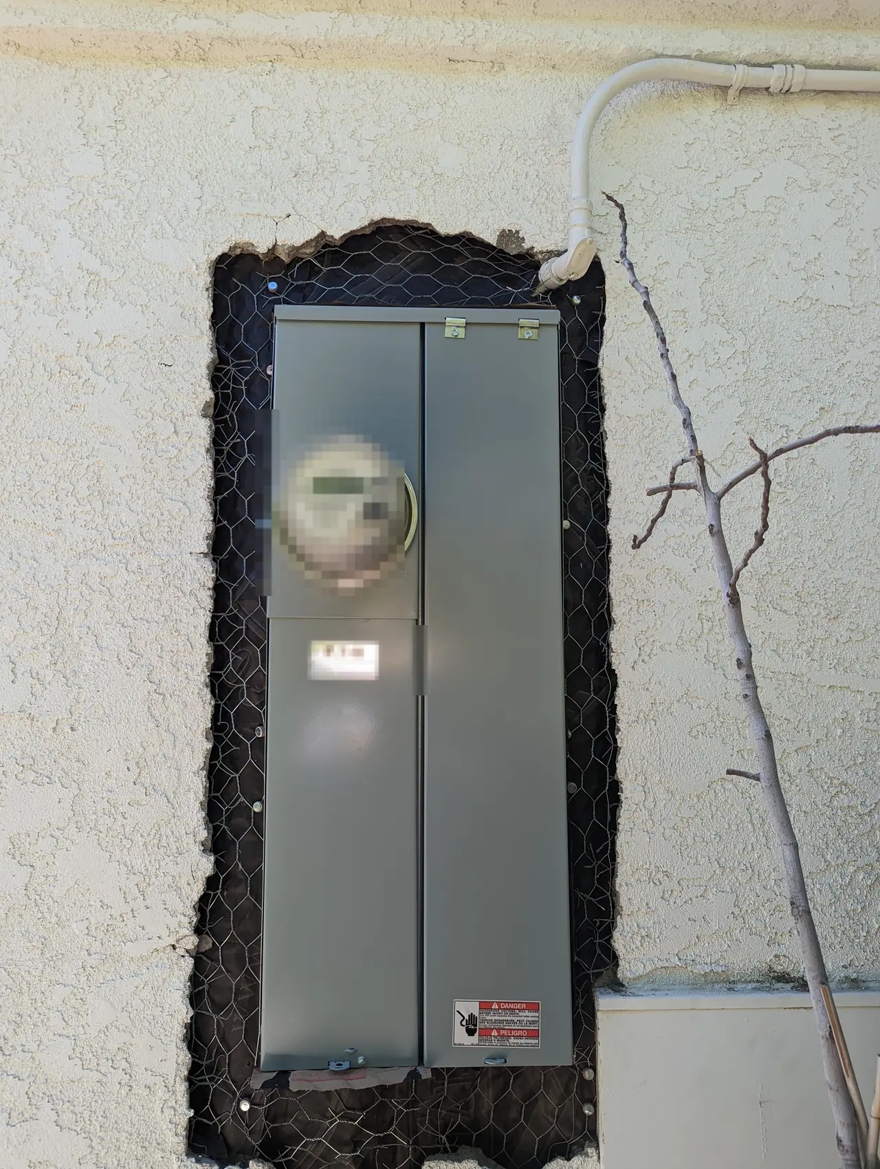 A service panel recessed into an opened stucco wall, Santa Clarita