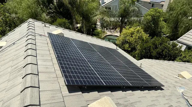 A solar array on a shingle roof with the neighborhood and hills behind it, Santa Clarita