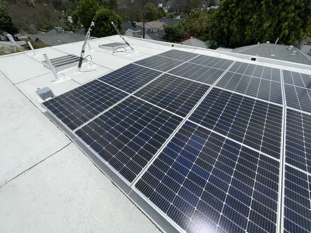 Solar modules on tilt racking above a white low-slope roof, Sherman Oaks