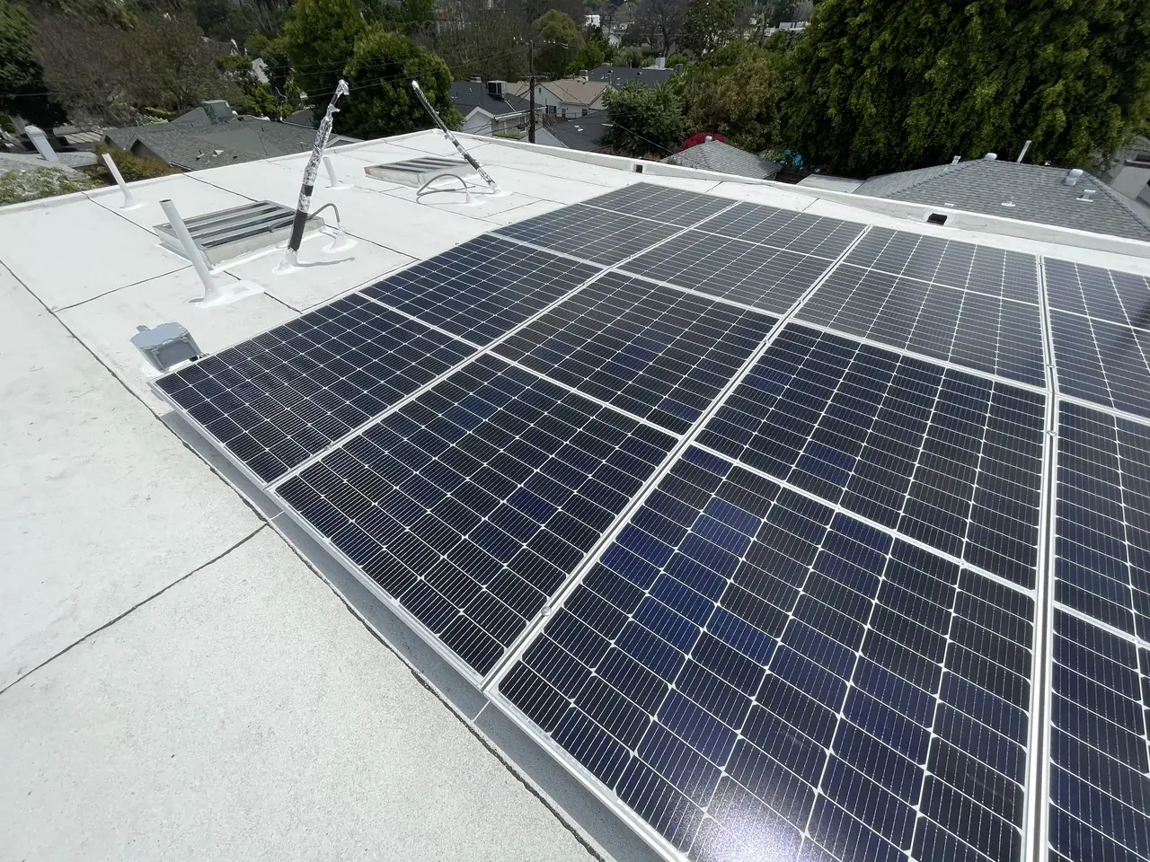 Solar modules on tilt racking above a white low-slope roof, Sherman Oaks