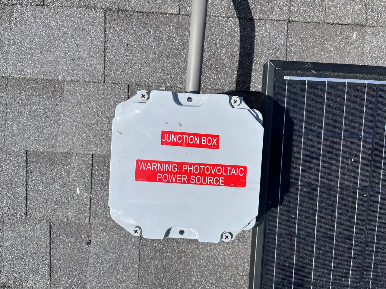 Roof junction box with a photovoltaic warning label on composition shingle, Sherman Oaks