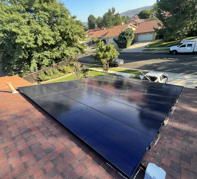 Solar array on a composition shingle roof in Simi Valley with the ridge and neighboring houses beyond