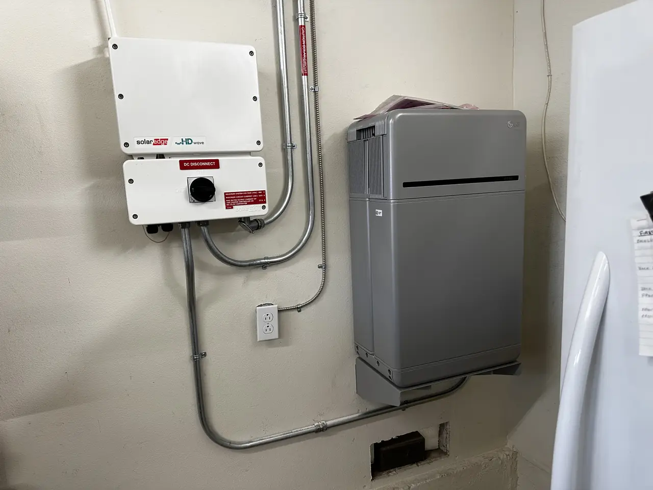 Battery and electrical equipment mounted on an exterior wall of a house in Simi Valley