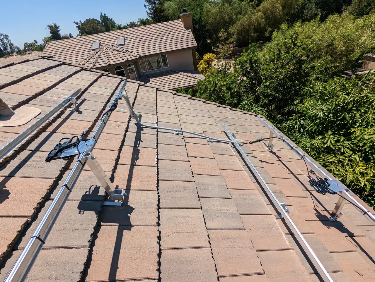 Mounting rails laid across a concrete tile roof in Simi Valley before the modules