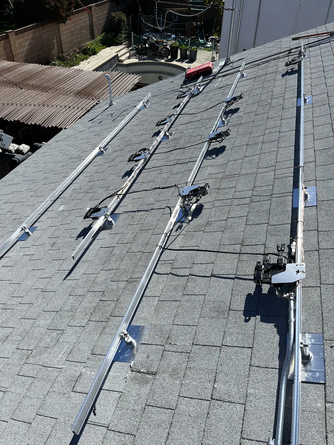 Mounting rails and microinverters installed on a shingle roof in Simi Valley before the modules