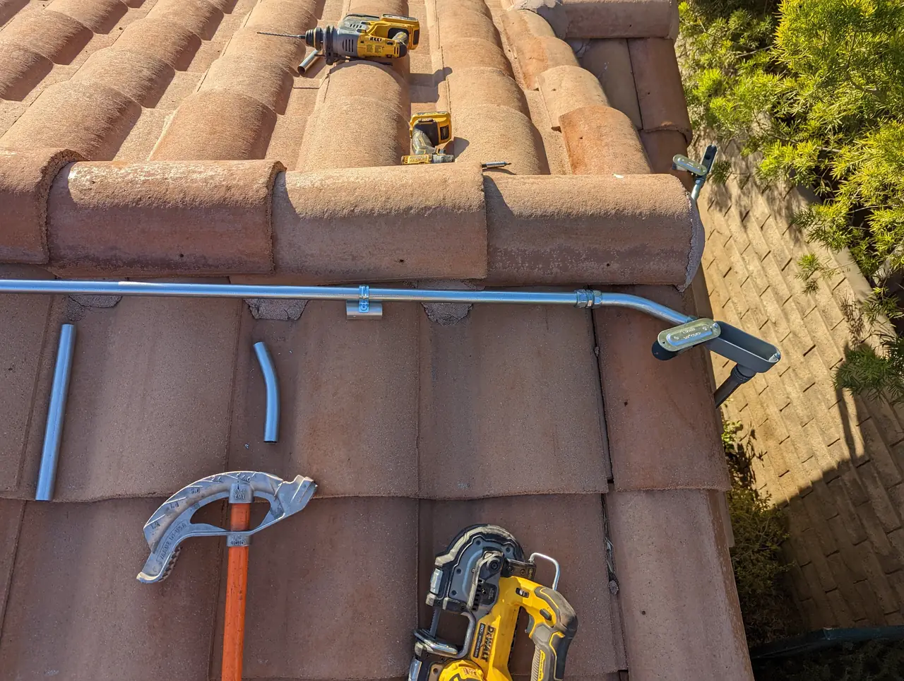 Conduit run clipped along the S-tile roof of a house in Simi Valley