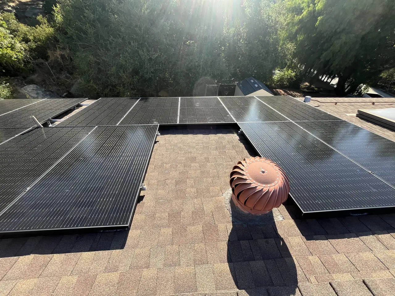Solar array laid out in sections across a shingle roof in Simi Valley with turbine vents between them