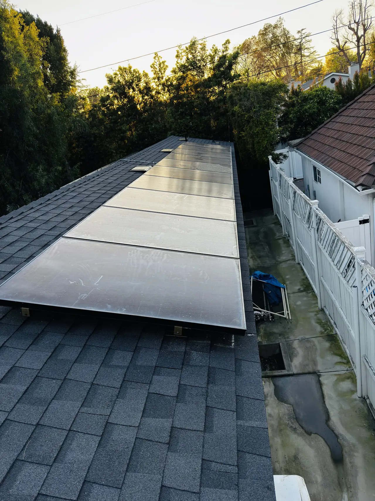 Finished solar array along a roof plane with trees and evening light, Studio City