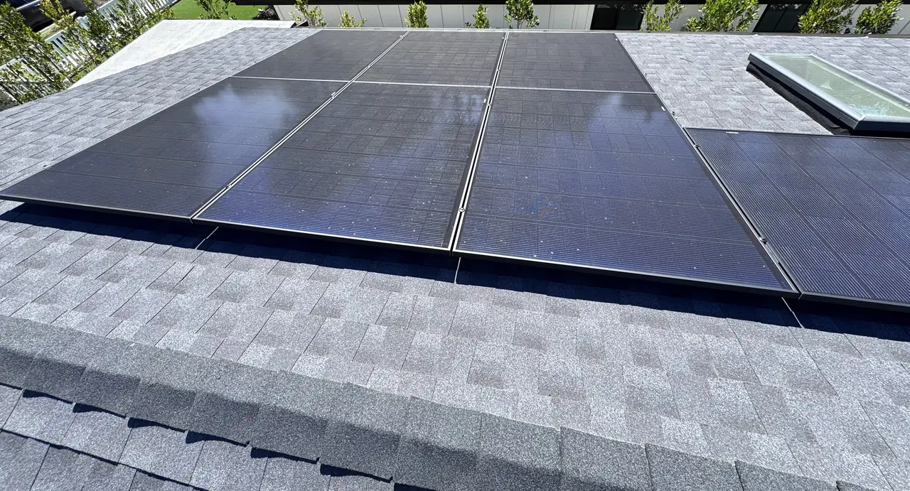 Finished solar array on a shingle roof beside a skylight, Studio City