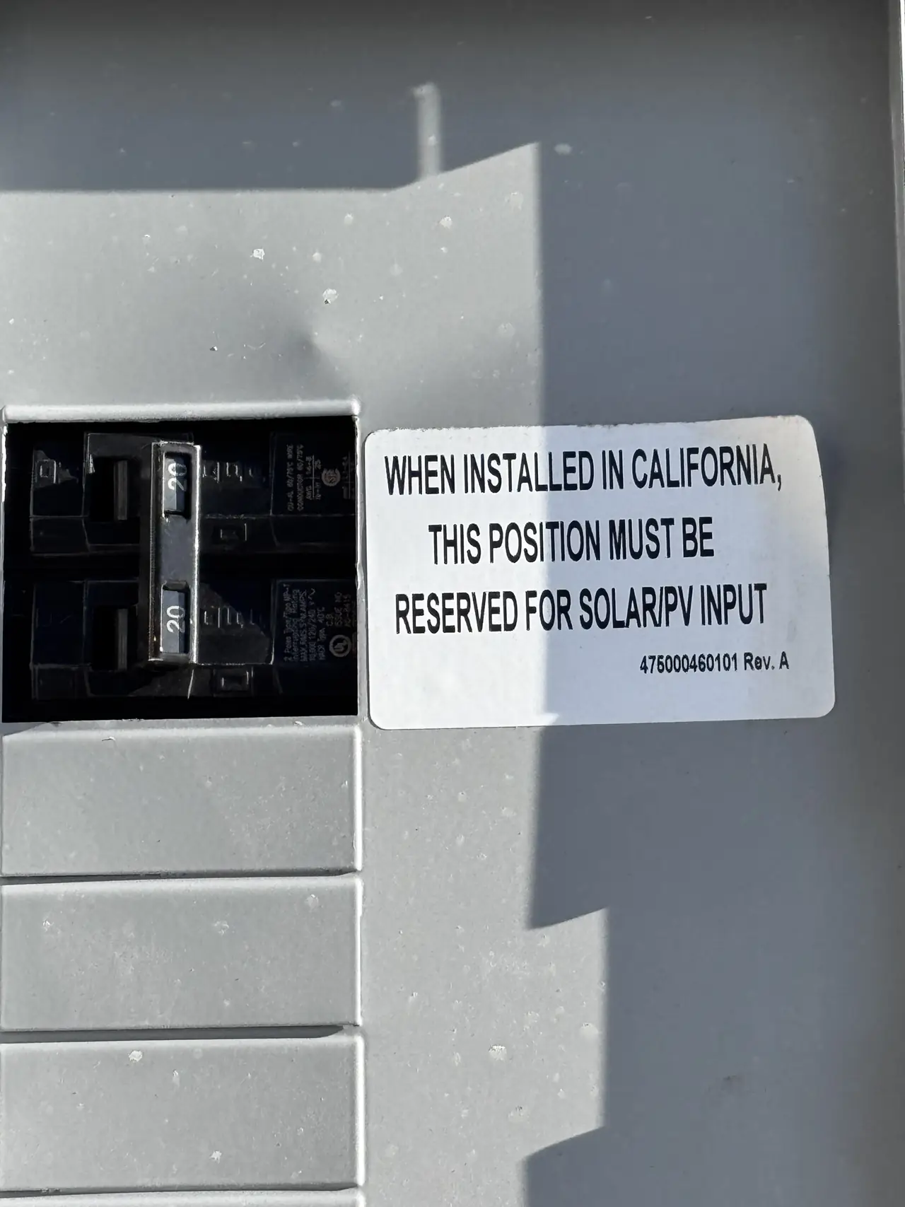 A breaker in a panel beside a label reading that in California the position must be reserved for solar or PV input, Sunland