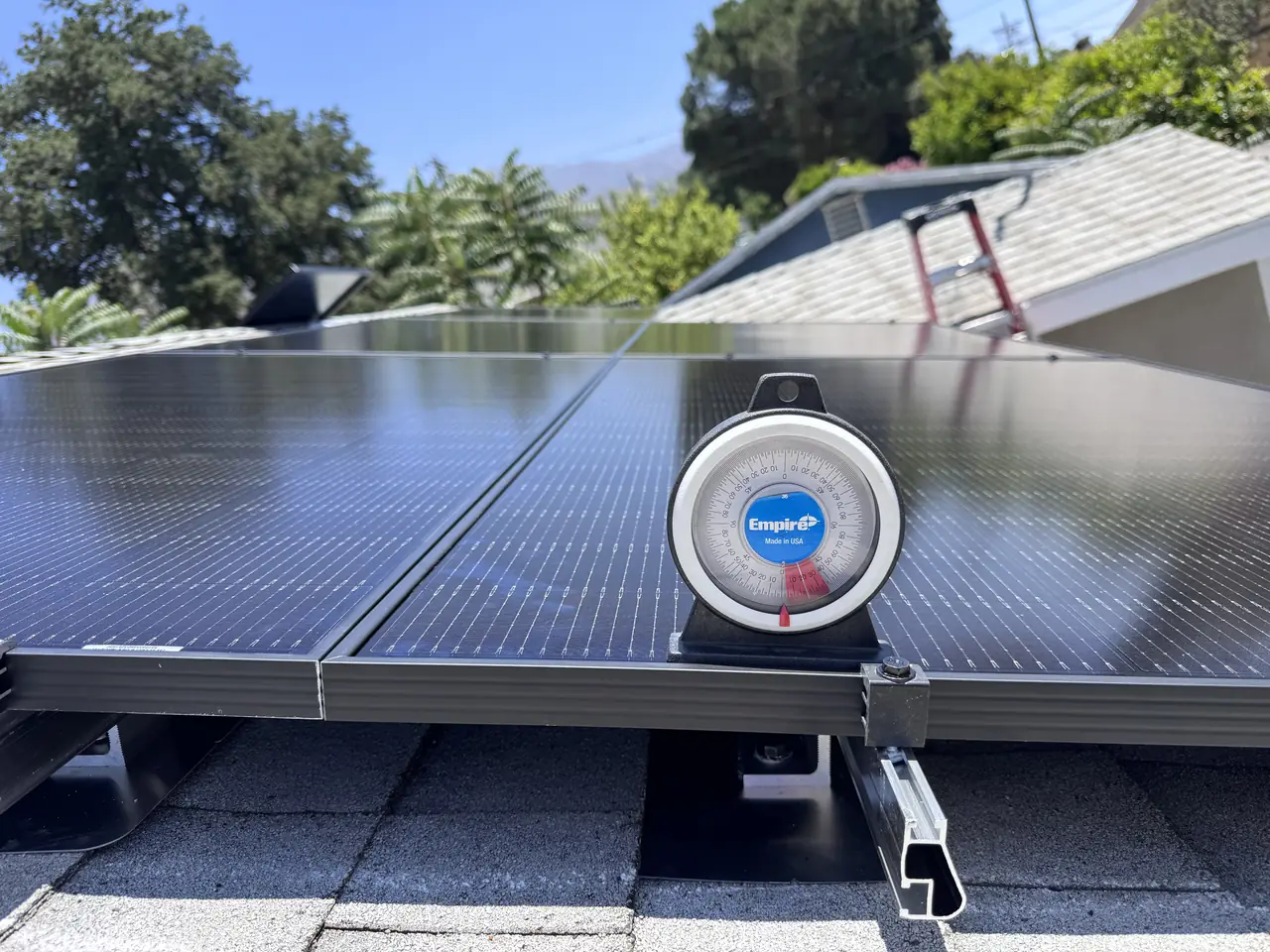 An inclinometer standing on a solar module to check the tilt of the array, Sunland
