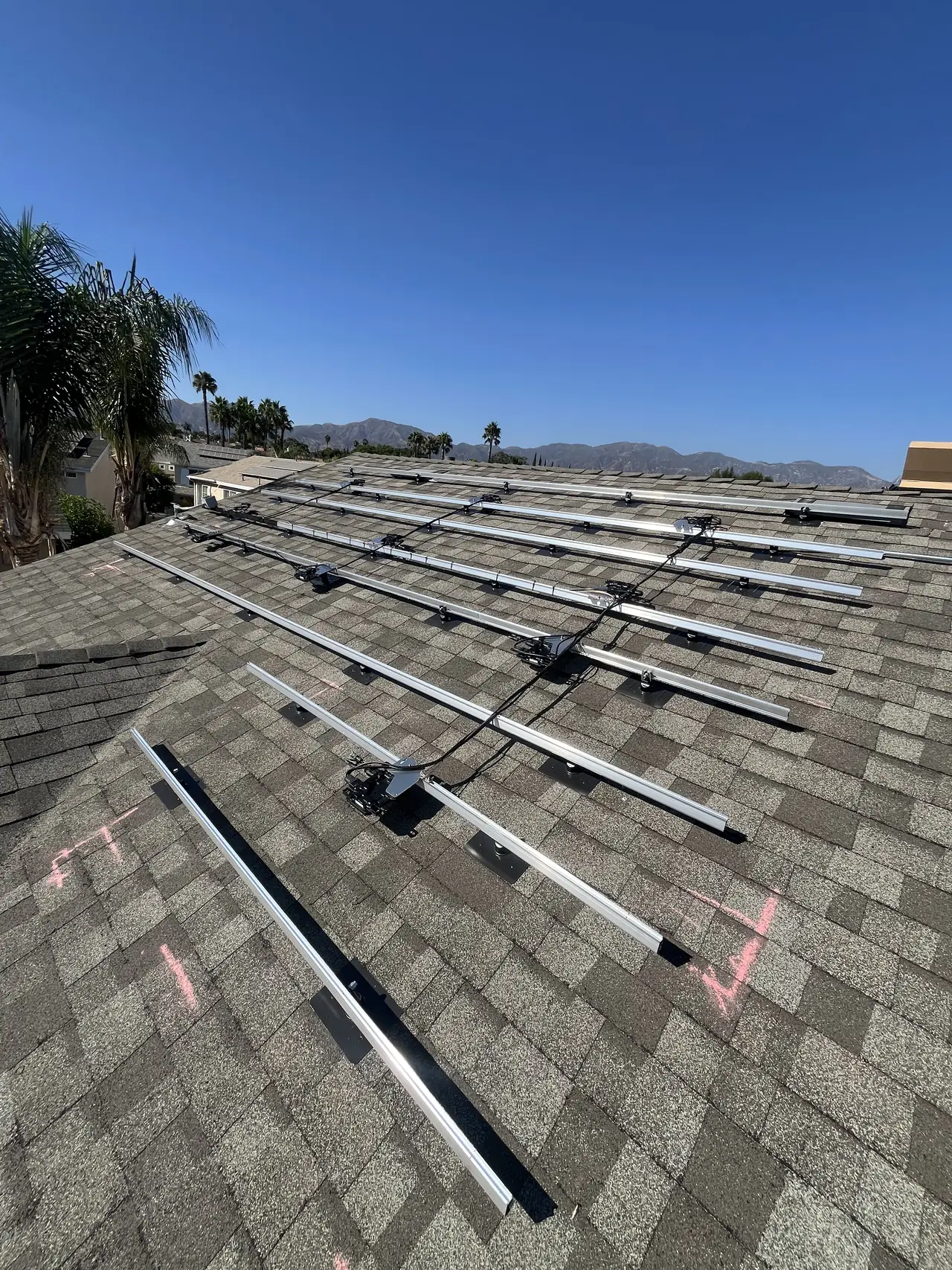 Racking rails laid out across a composition shingle roof, Sylmar