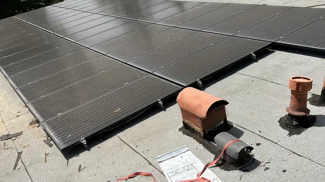 New black solar modules on a rebuilt low-slope built-up roof with new roof vents, Tarzana