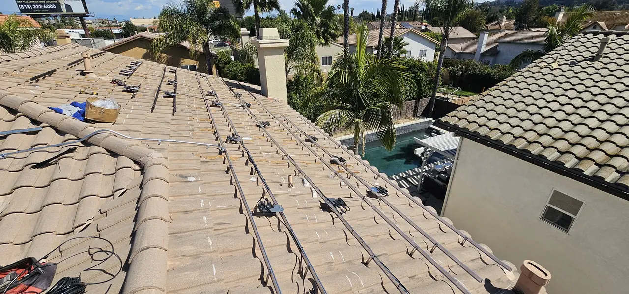 Mounting rails on tile hooks laid across a concrete S-tile roof before the modules go on, Tarzana
