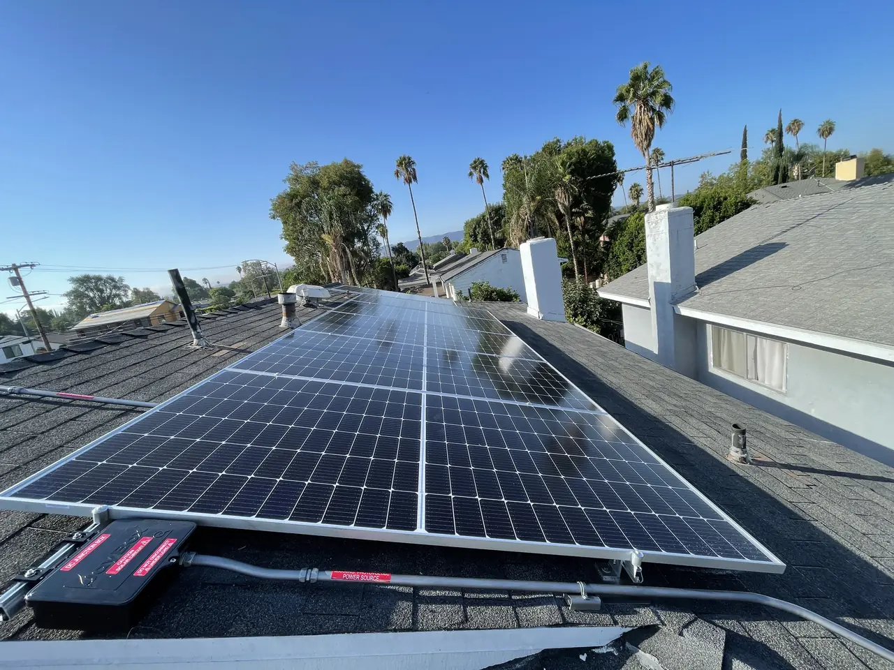 Solar modules on a composition shingle roof with rapid shutdown labels, Tarzana