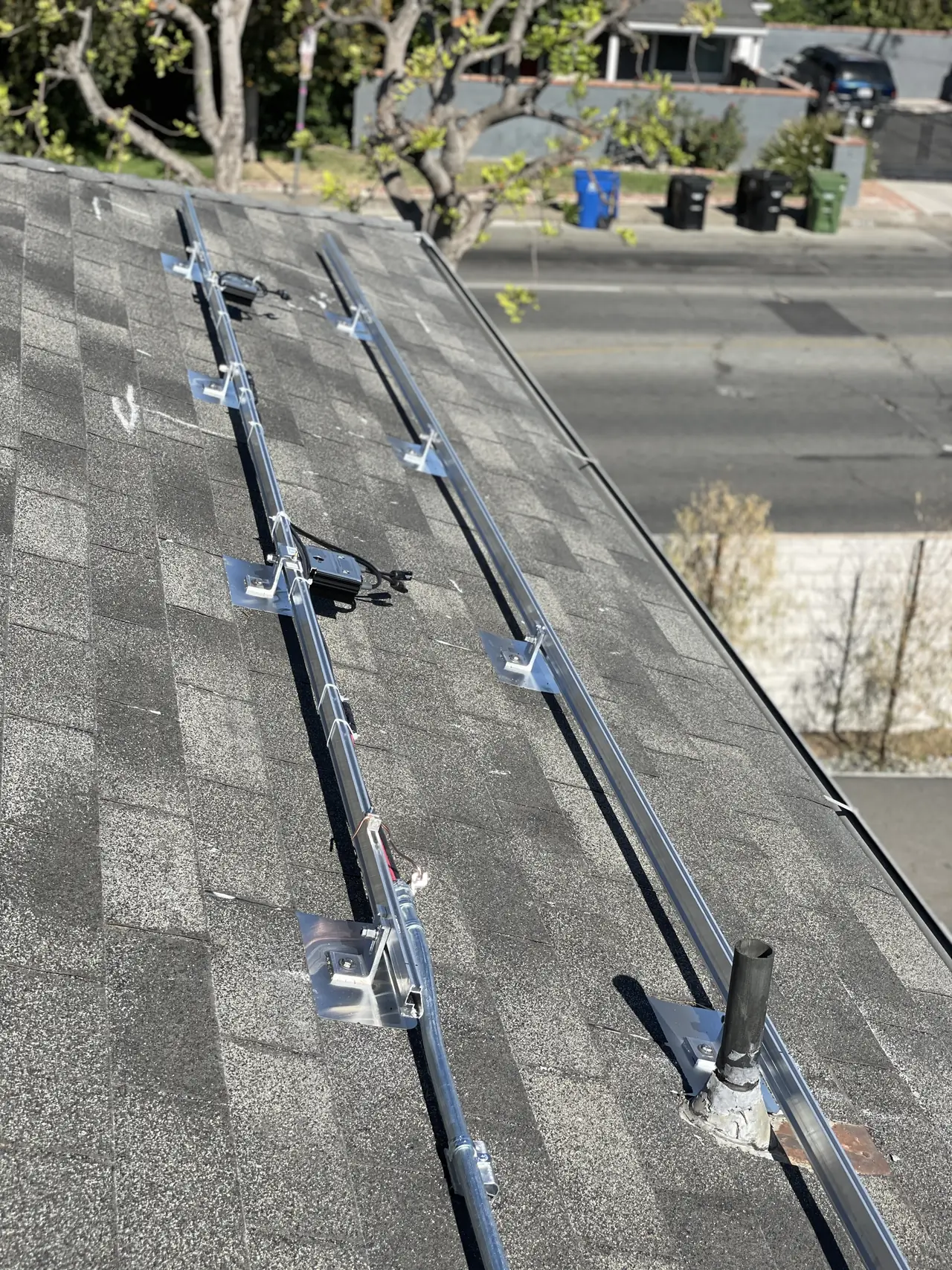 Mounting rails on flashed L-foot attachments laid across a composition shingle roof, Tarzana