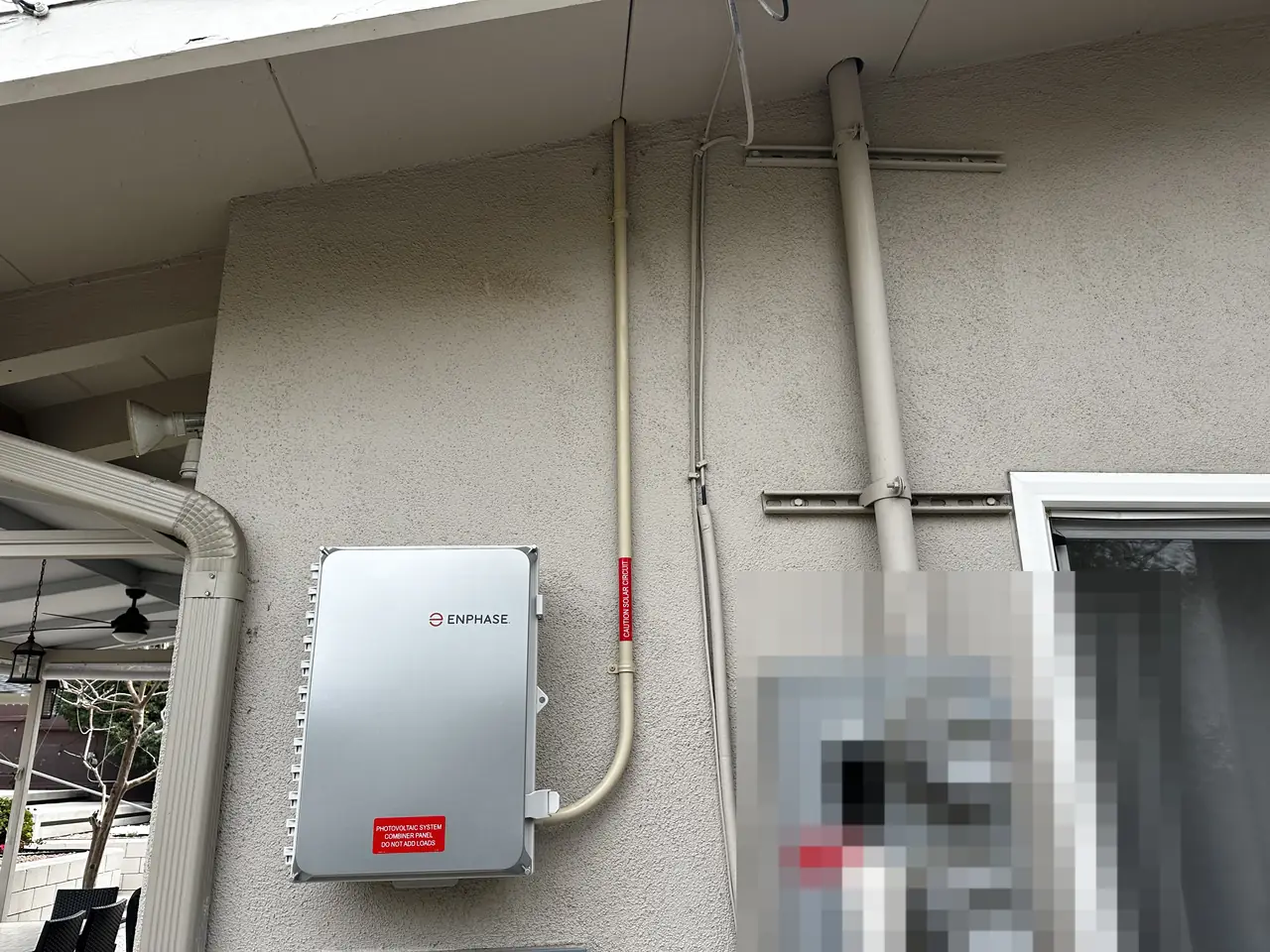 An Enphase combiner box beside two electric meters on a stucco wall, Tujunga