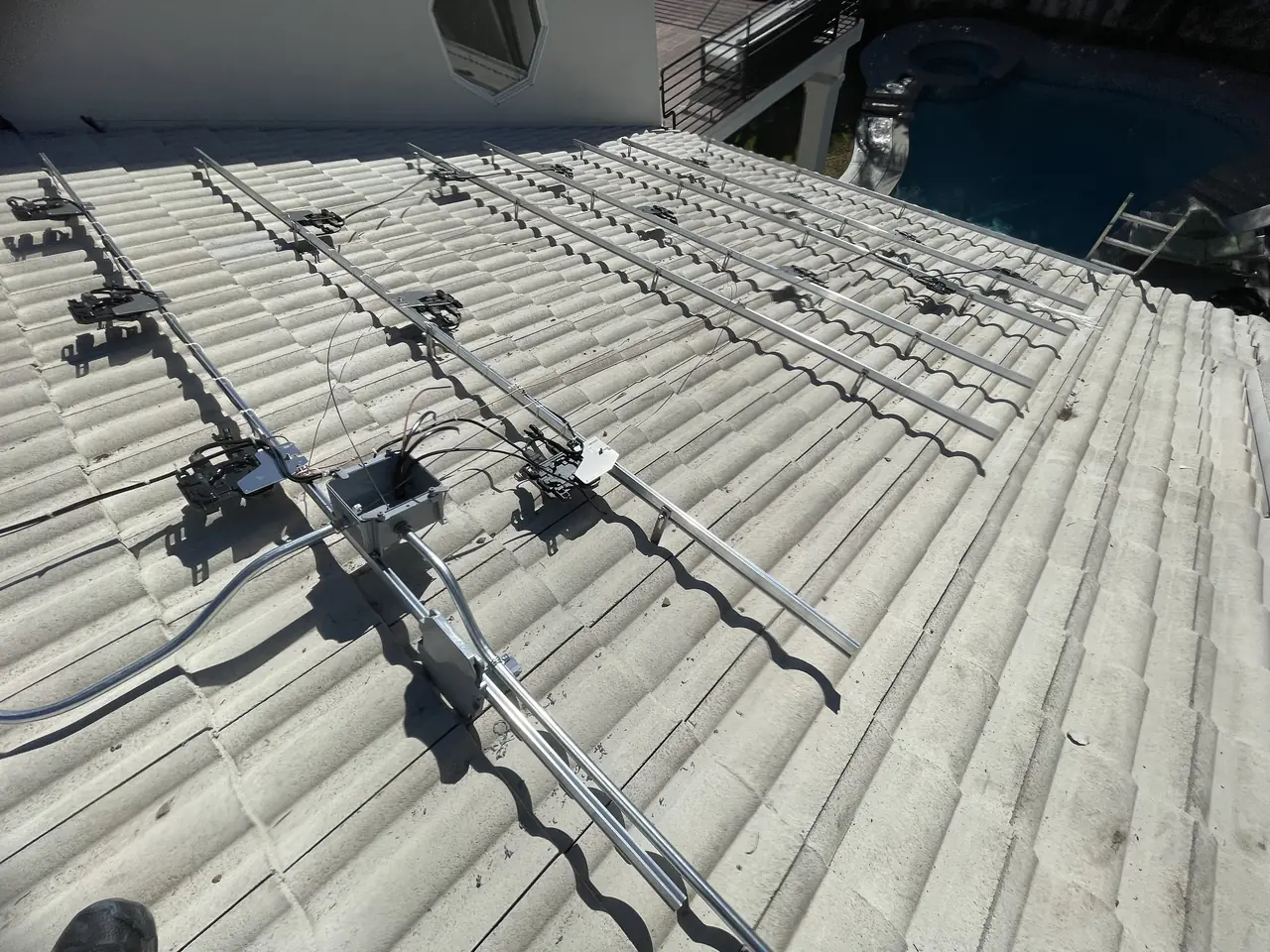 Mounting rails and hardware set across a concrete tile roof before the modules go on, Van Nuys, Los Angeles