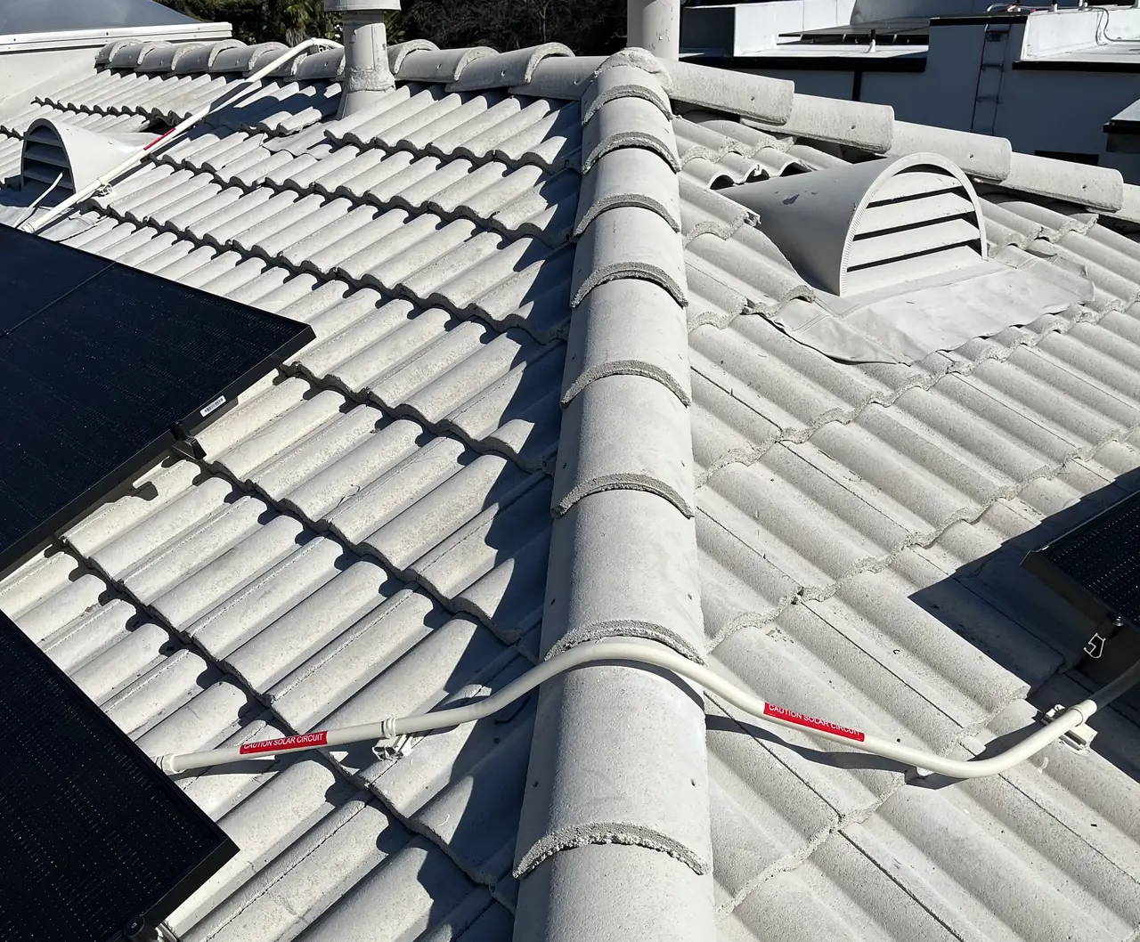 Black modules meeting the ridge of a concrete tile roof, Van Nuys, Los Angeles