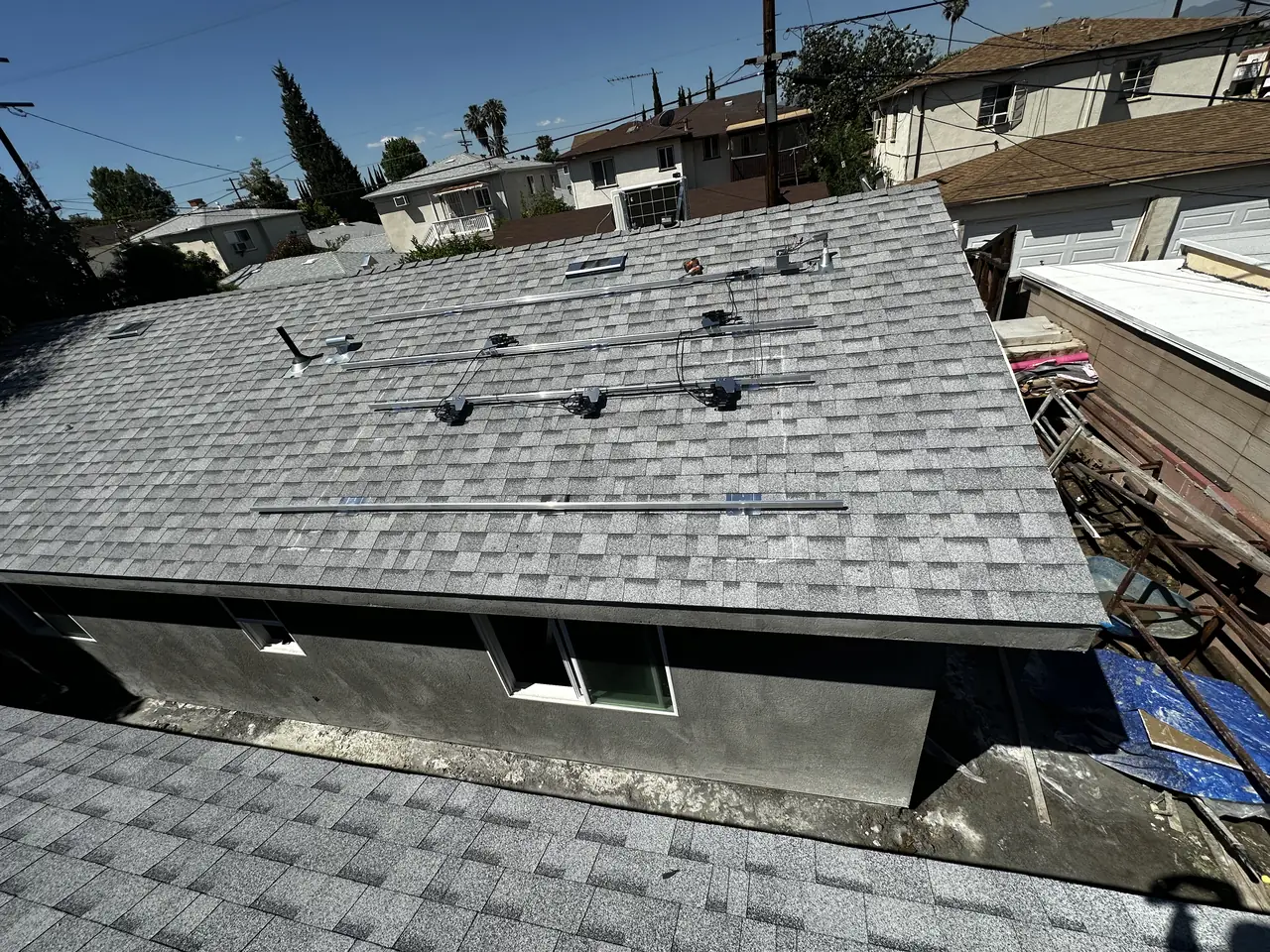 New light-colored shingle roofs of two small buildings close together on a narrow lot, Van Nuys, Los Angeles