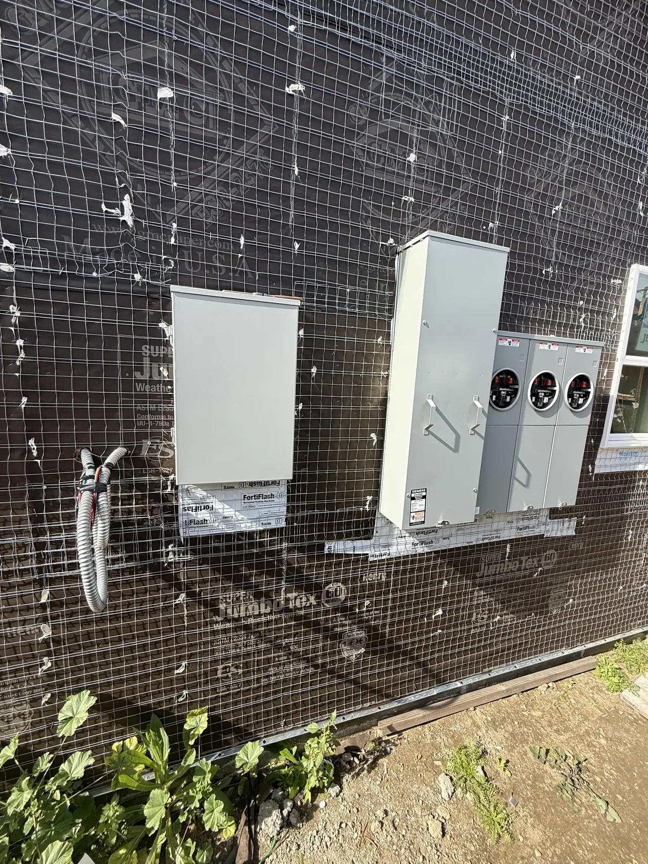 A wall of new construction carrying several electric service enclosures side by side, Van Nuys, Los Angeles