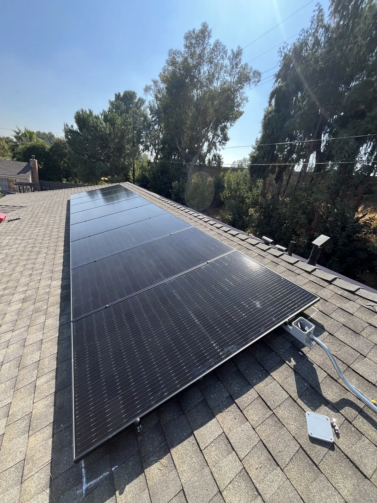 Two separate groups of modules on adjacent planes of a hip roof with trees beyond, Van Nuys, Los Angeles