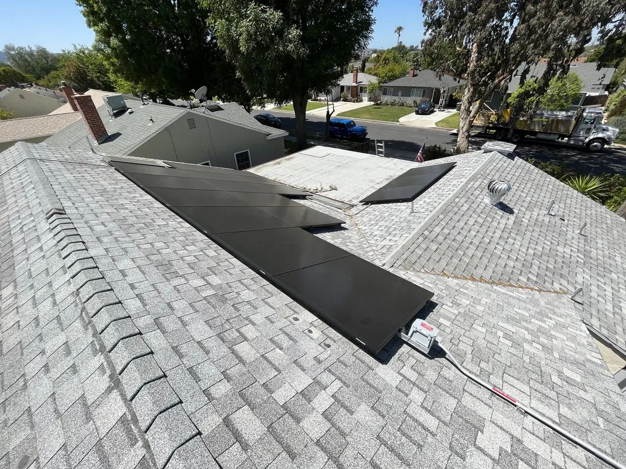 Wide view across a hip roof with several separate groups of modules and skylights between them, Van Nuys, Los Angeles