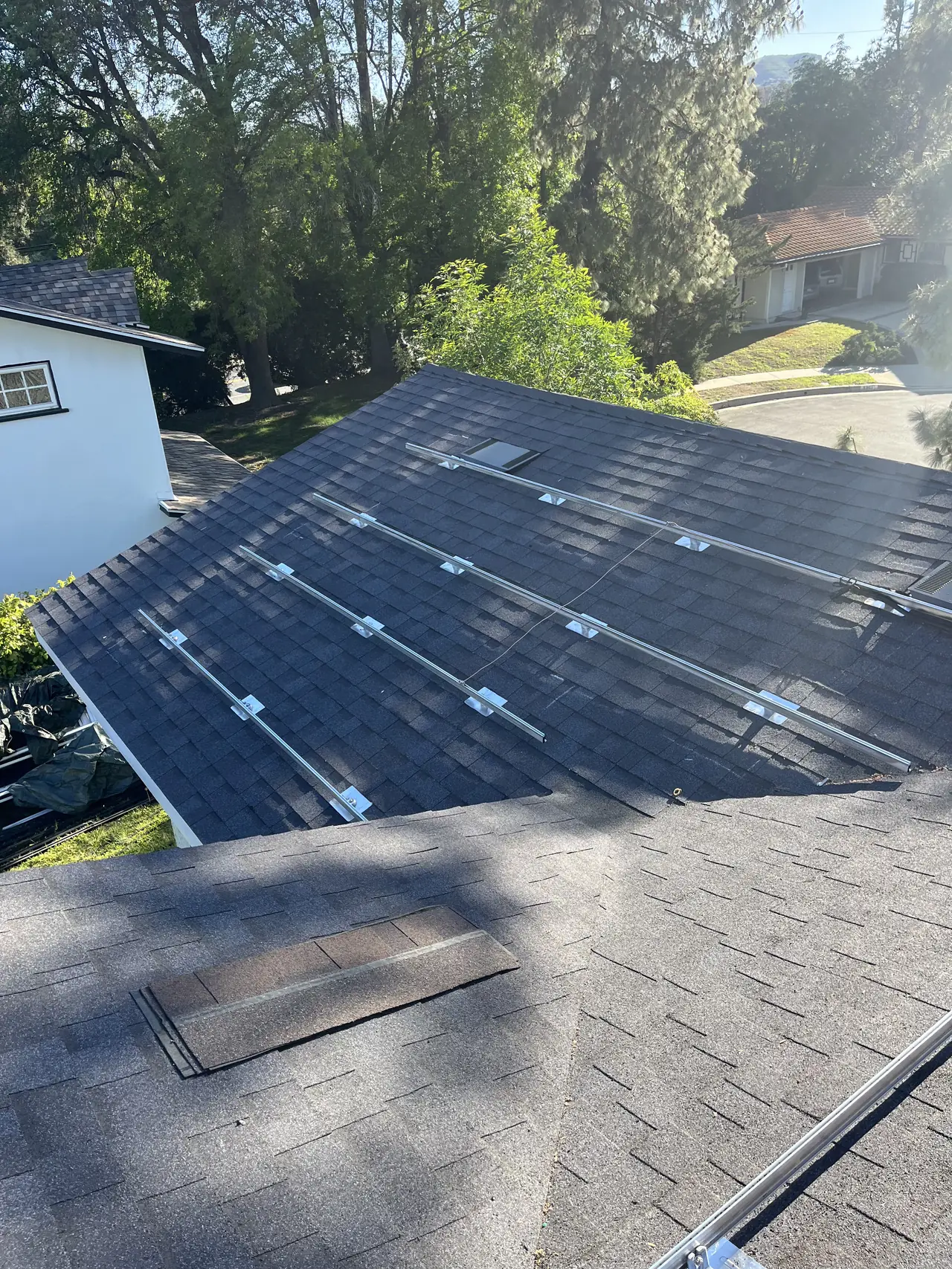 Mounting rails laid out across a composition shingle roof plane, West Hills
