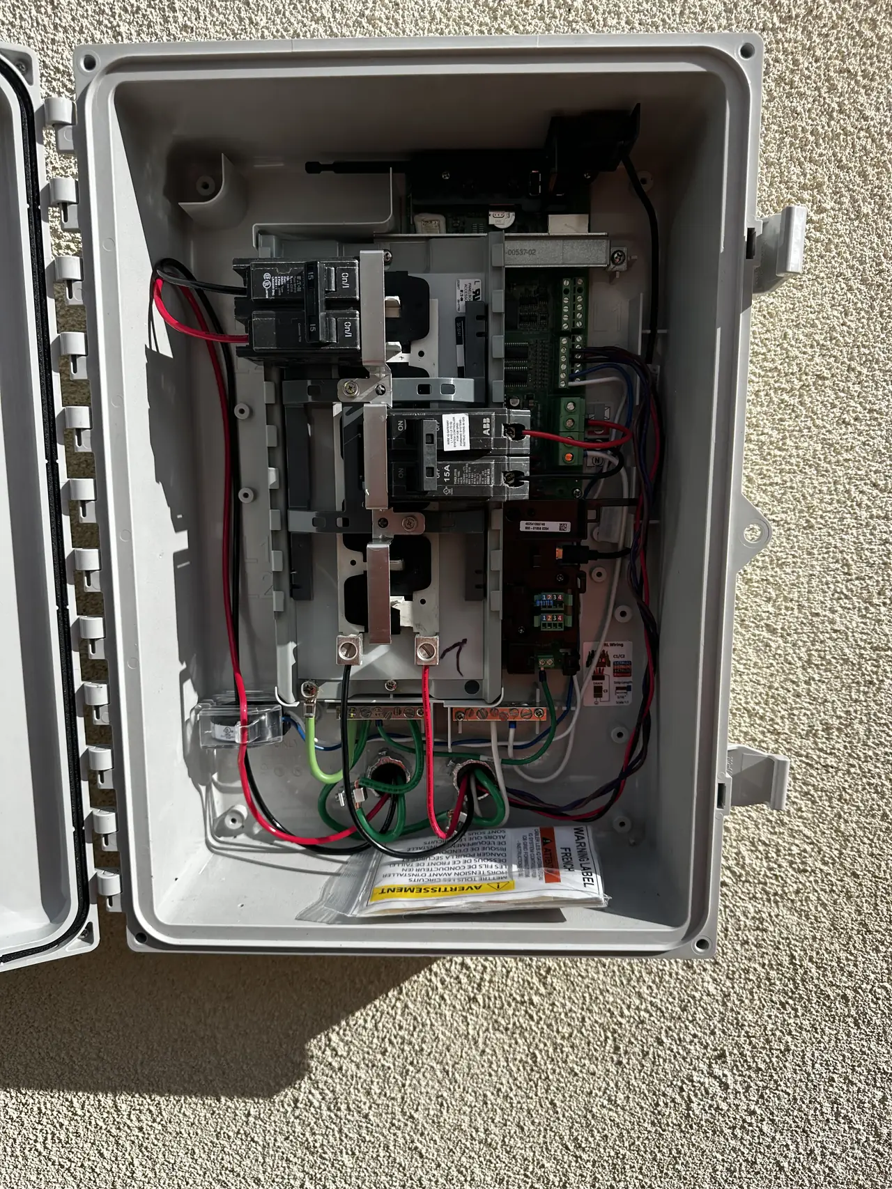 Enphase combiner enclosure with wiring on an exterior wall, Winnetka