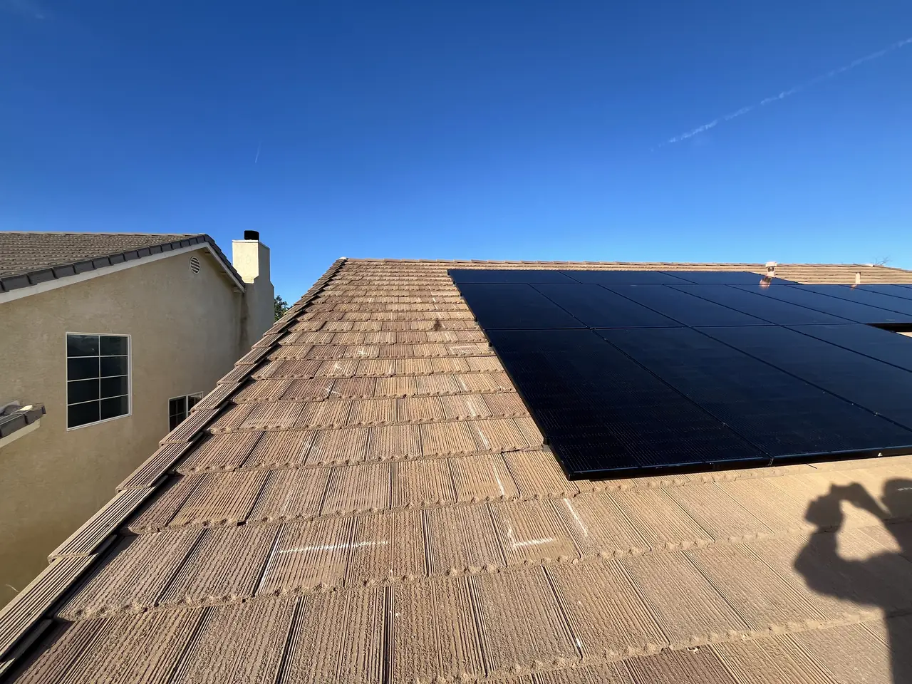 Solar array across a concrete tile roof seen from the ridge, Winnetka