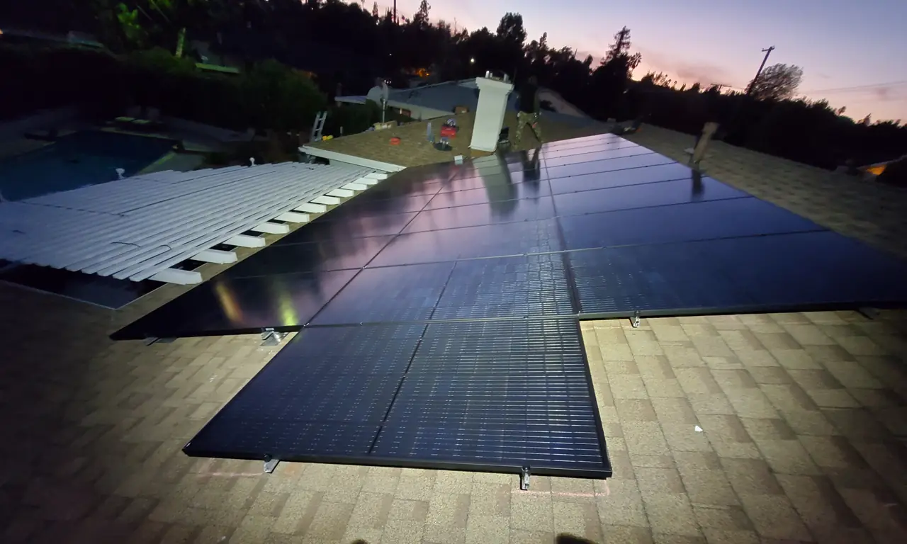 The completed black array seen along the ridge of the shingle roof with neighboring houses beyond, Woodland Hills