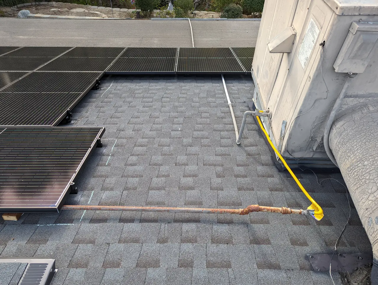 Solar modules being laid out and set on a new gray shingle roof during installation, Woodland Hills