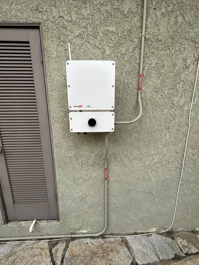 A replacement string inverter newly mounted on an exterior wall with conduit running to it, Woodland Hills