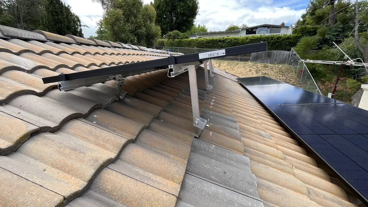 A mounting standoff set between courses of concrete roof tile with the rail above it, Woodland Hills