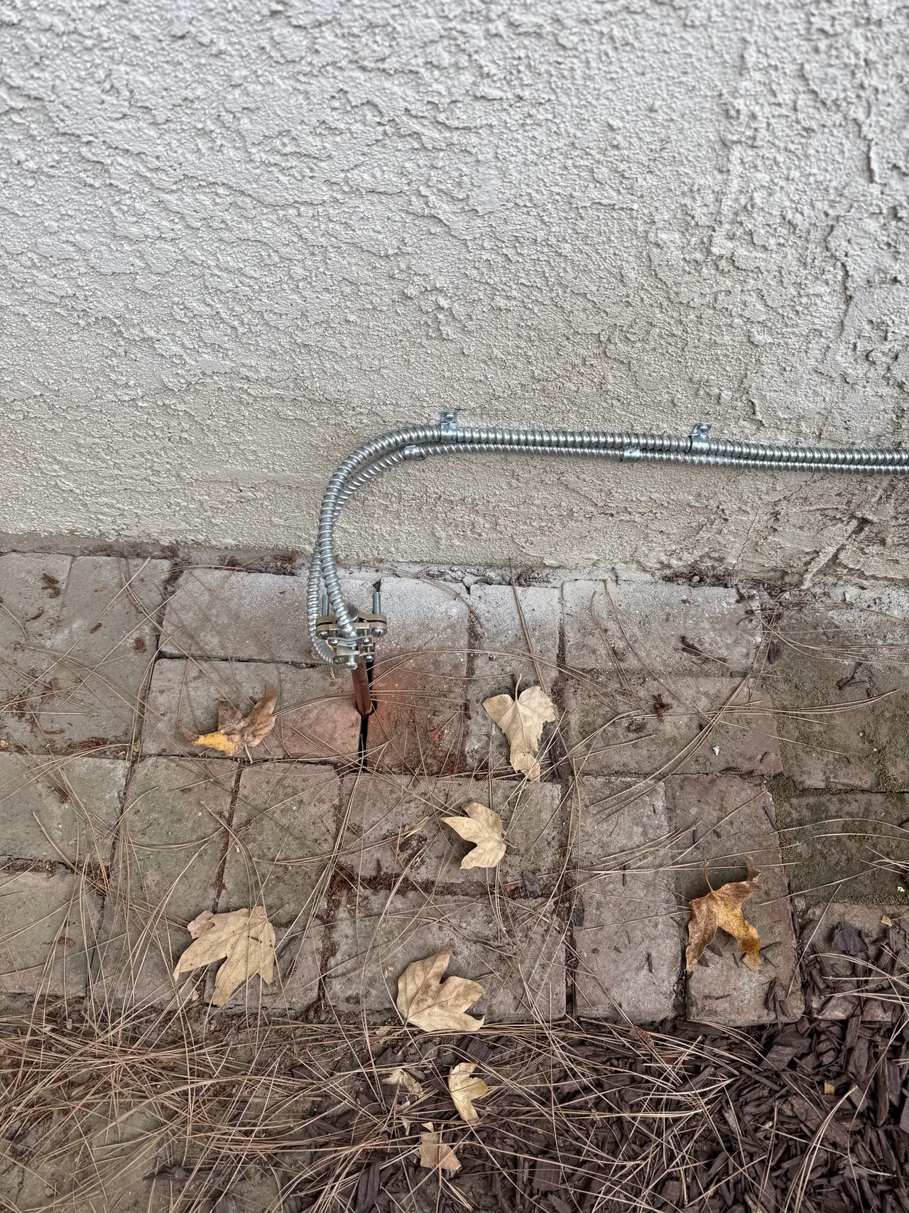 A new service conduit run along the base of a stucco wall at ground level, Woodland Hills