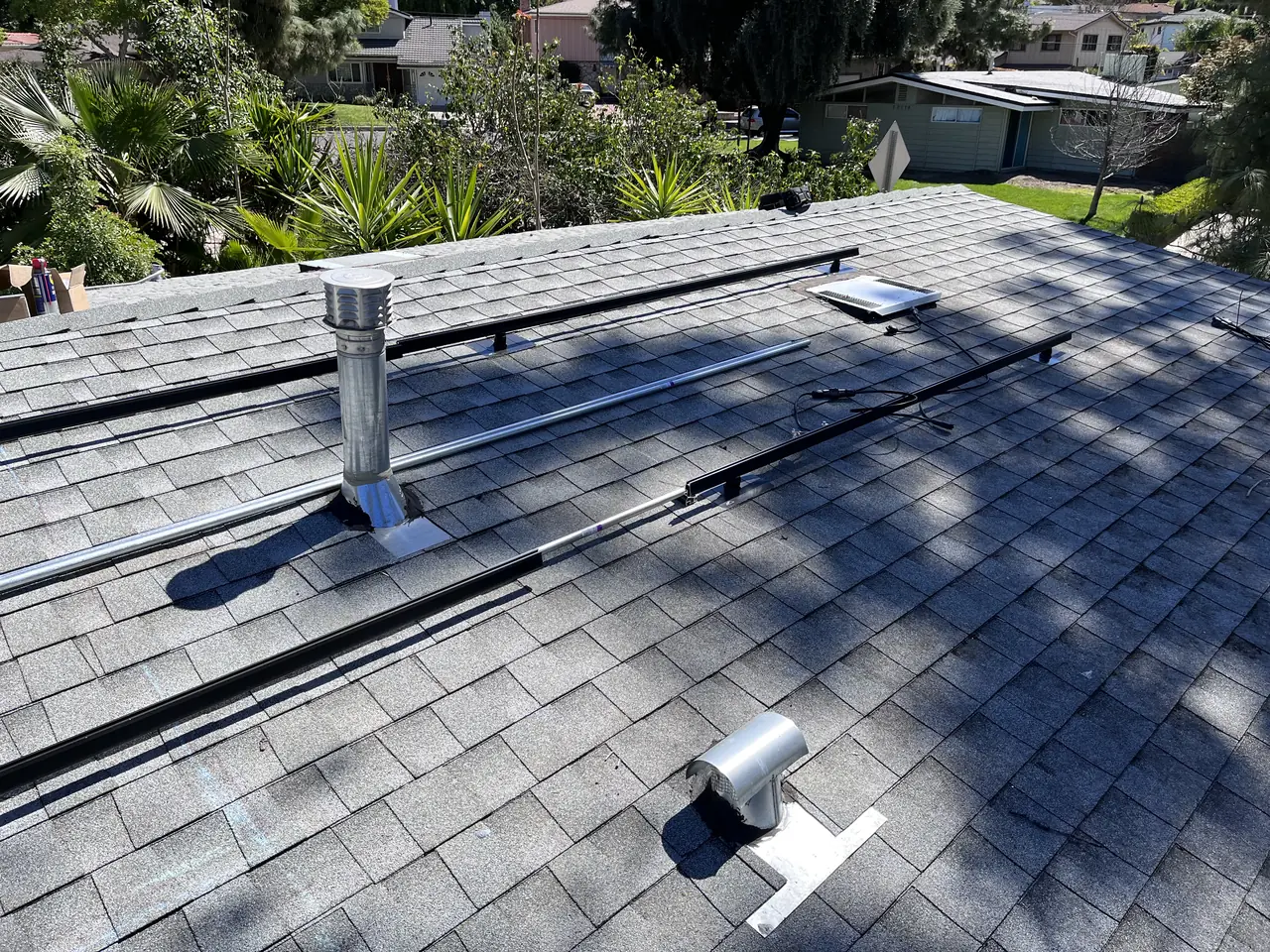 A mounting standoff and rail set on the shingle roof with the conduit run beside it, Woodland Hills